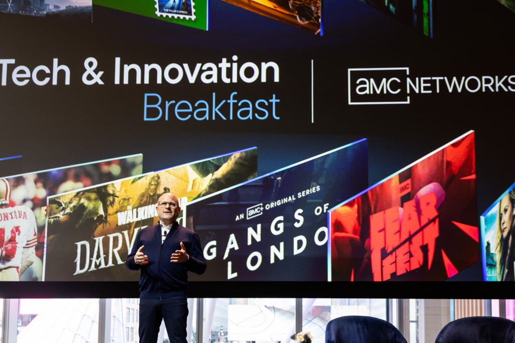 AMC Networks Evan Adlman presenting at their annual Tech & Innovation Breakfast in front of screen 